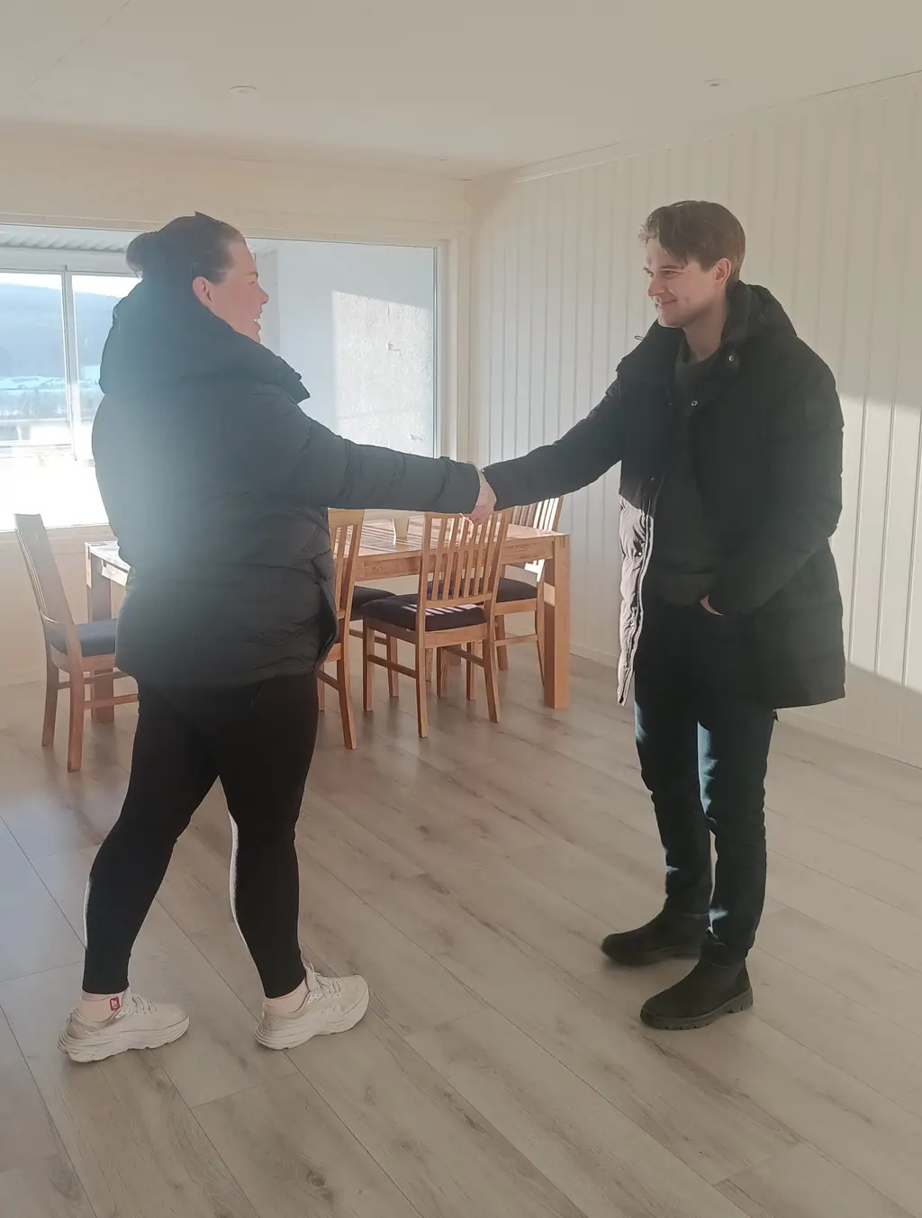 Boligselger og kjøper håndhilser etter vellykket salg