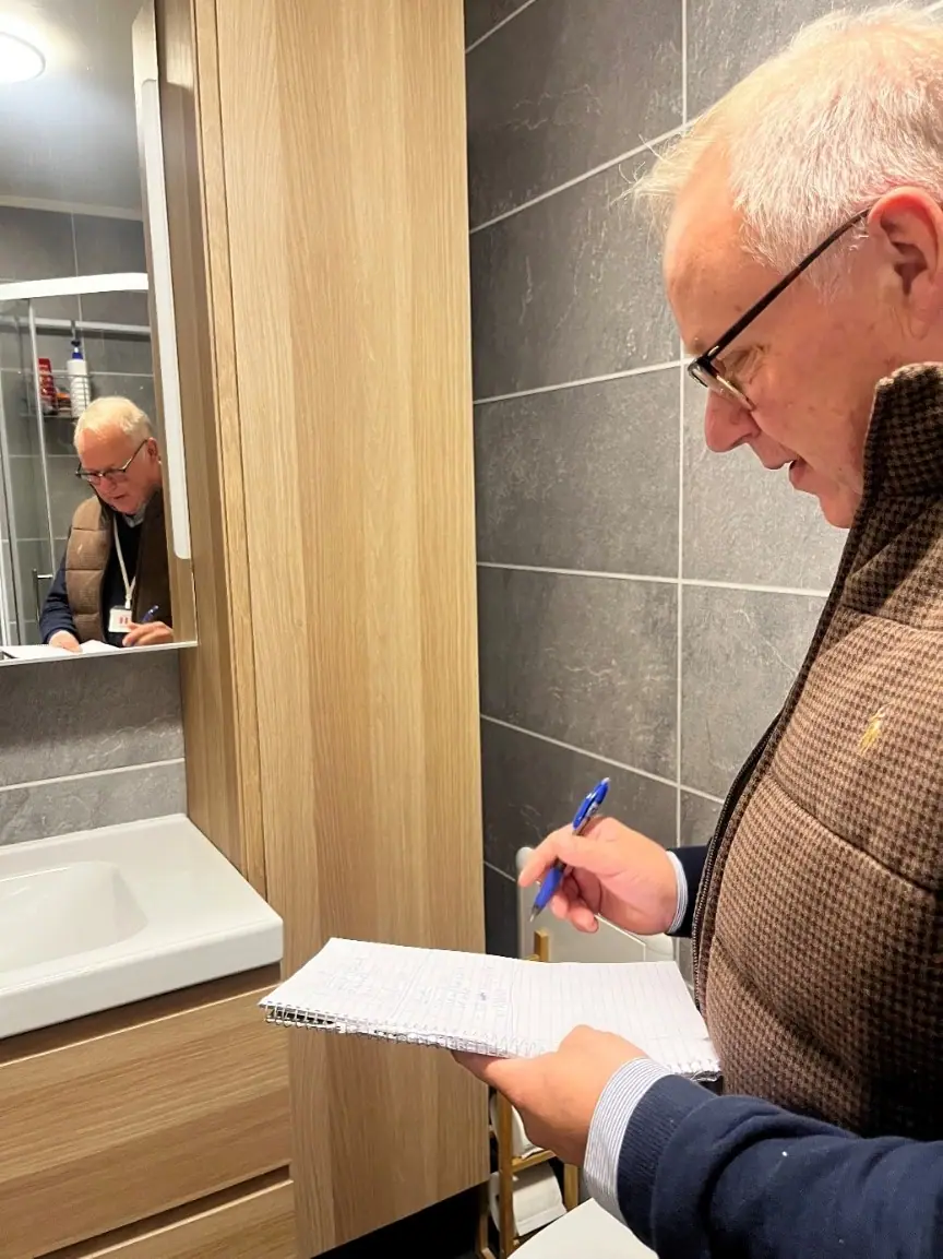Takstmann gjør notater under befaring av badet